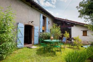 a table and chairs in front of a house at L'atelier du huchier in Poucharramet