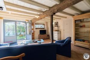 a living room with a blue couch and a table at L'atelier du huchier in Poucharramet