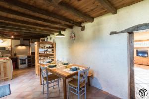 a kitchen and dining room with a wooden table and chairs at L'atelier du huchier in Poucharramet