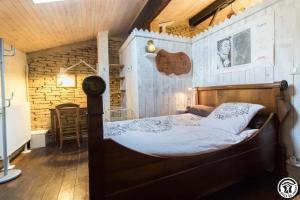 a wooden bed in a room with a wooden ceiling at L'atelier du huchier in Poucharramet