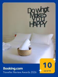 ein weißes Bett mit einem Korb voller Handtücher darauf in der Unterkunft EcoLiving Casa Vacanze in Torre Lapillo