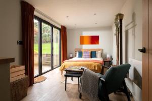 a bedroom with a bed and a table with a chair at Cotswolds Cabin in Stonesfield