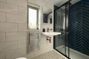 a bathroom with a sink and a shower at Cotswolds Cabin in Stonesfield