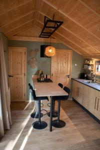 a kitchen with a table and chairs in a room at Kapschuur in Zuidwolde