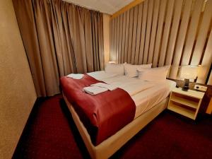 a bedroom with a large bed with two towels on it at Hotel Augustin Komfort Leipzig in Leipzig