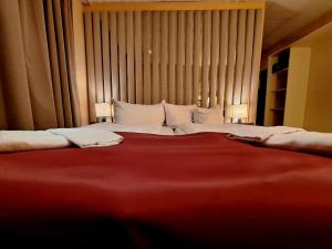 a large bed with white pillows in a room at Hotel Augustin Komfort Leipzig in Leipzig +1 photo