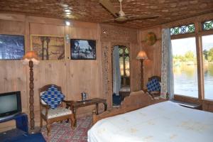 a bedroom with a bed and a tv in a room at Jackson Heights Houseboats in Srinagar