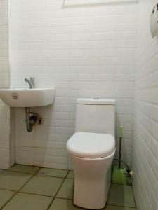 a bathroom with a toilet and a sink at Rustic Retreat Three Bedroom House in Pagdalagan +10 photos
