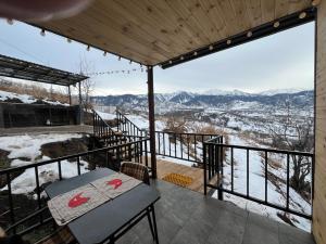 a balcony with a table and a view of the mountains at Kainar Glamp Домик в горах с террасой и прекрасным видом на горы in Besqaynar
