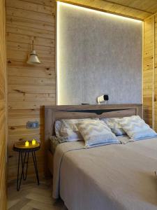 a bedroom with a bed and a side table at Kainar Glamp Домик в горах с террасой и прекрасным видом на горы in Besqaynar