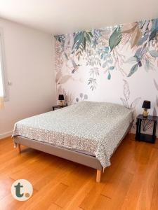 a bedroom with a bed with a floral wall at Tranquiloue - Maison de Campagne - PuyduFou in Treize-Vents