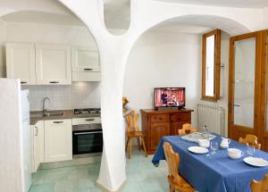 a kitchen with a table with a blue table cloth at Valledoria holiday flats in Valledoria