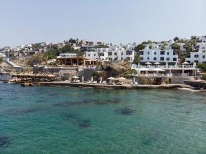 a group of white buildings on the shore of the water at YAZ Yalıkavak in Yalıkavak