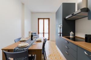 a kitchen with a wooden table and a dining room at Casa Stella Otranto Centre - Sea View, AC & WiFi in Otranto
