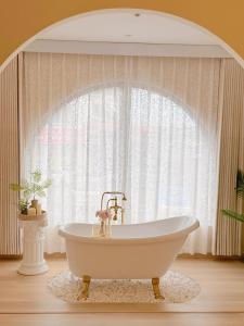 a white bath tub in front of a window at The Cozy Cottage Semporna in Semporna