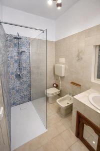 a bathroom with a shower and a toilet and a sink at Aeolian Apartments in Lipari