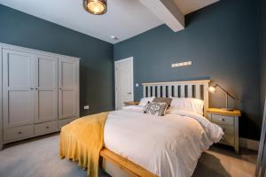 a bedroom with a bed and a blue wall at The Leiston, Valley Road in Leiston