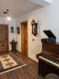 a living room with a piano and a door at Doa Boutique Hotel in Peje