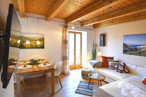 a living room with a couch and a table at Charmante Chiemgauwohnung in Wasserburg am Inn