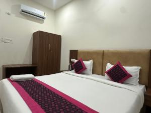 ein Schlafzimmer mit einem großen Bett und rosa Kissen in der Unterkunft Hotel La Opera in Gwalior + 15 Fotos