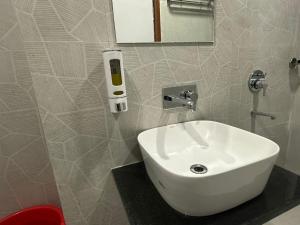 ein Badezimmer mit Waschbecken und einem Telefon an der Wand in der Unterkunft Hotel La Opera in Gwalior