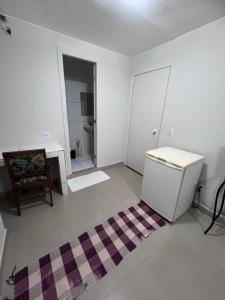a white room with a toilet and a rug at Pousada 705 norte 1 in Brasília