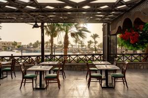 a restaurant with tables and chairs and a view of the water at Blend Elphistone Resort Marsa Alam in Abu Dabbab