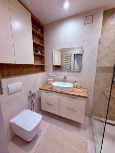 a white bathroom with a sink and a toilet at Центр стадіон Central Сity Замкова in Rivne