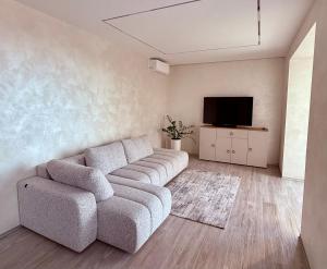 a living room with a couch and a flat screen tv at Центр стадіон Central Сity Замкова in Rivne