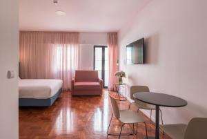 a hotel room with a bed and a table and chairs at LSA Campos by Numa in Lisbon
