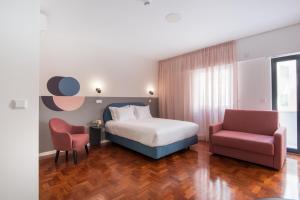 a hotel room with a bed and a chair at LSA Campos by Numa in Lisbon