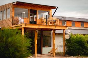 a house with a deck with chairs on it at Hosteria Casa kuyen in El Calafate