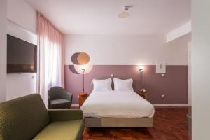 a hotel room with a bed and a couch at LSA Campos by Numa in Lisbon