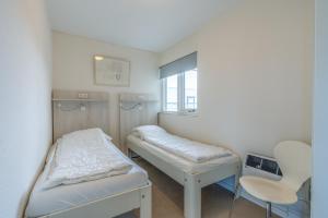 a small room with a bed and a chair at Appartementencomplex Juliana 152 in De Koog +5 photos