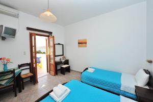 a living room with a blue couch and a table at Pension Sofia Amorgos-Katapola in Katapola