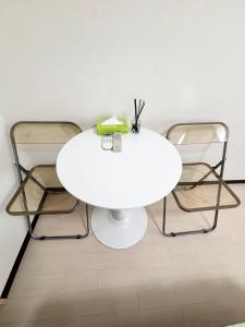 a white table and three chairs in a room at 551 Namba in Osaka