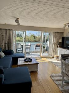 a living room with a couch and a table at Peaceful Lakefront Escape w Deck Views in South Cerney