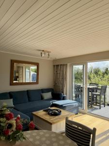 a living room with a blue couch and a table at Peaceful Lakefront Escape w Deck Views in South Cerney