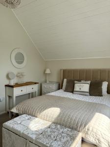 a bedroom with a bed and a table and a mirror at Peaceful Lakefront Escape w Deck Views in South Cerney