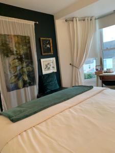 a bedroom with a large bed and a window at Chy Sabona - Front Room in Penzance +2 photos