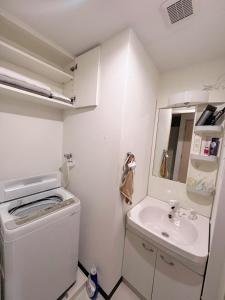 a small bathroom with a washing machine and a sink at 551 Namba in Osaka
