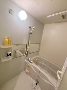 a bathroom with a bath tub and a mirror at 551 Namba in Osaka