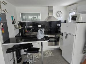 a kitchen with a counter and a sink and a refrigerator at Petite maison T2 in Valence