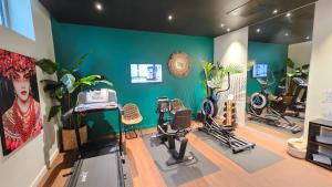 a room with a gym with exercise equipment and plants at Aiden by Best Western Lorient Centre in Lorient
