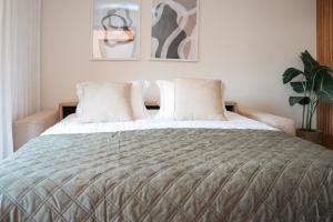 a bedroom with a large bed with two pillows at Magníficos Dias Atlânticos Studio in Moledo