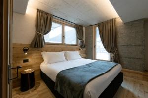 a bedroom with a large bed in front of a window at Grotta Bàlzer in Valdidentro