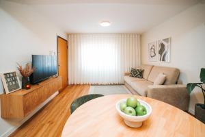 a living room with a table with a bowl of apples on it at Magníficos Dias Atlânticos Studio in Moledo