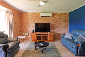 a living room with two couches and a flat screen tv at Pamusha 2 in Geraldton