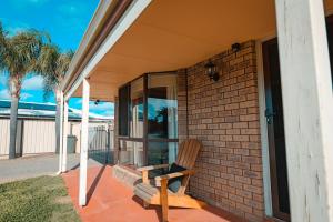 a wooden chair sitting on the porch of a house at Pamusha 2 in Geraldton