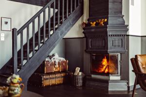 a fireplace in a living room with a staircase at Le Fitz Roy, a Beaumier hotel in Val Thorens